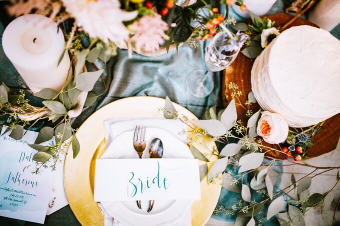 Ein Tischgedeck für eine Hochzeit mit Blumen und Eukalyptus.