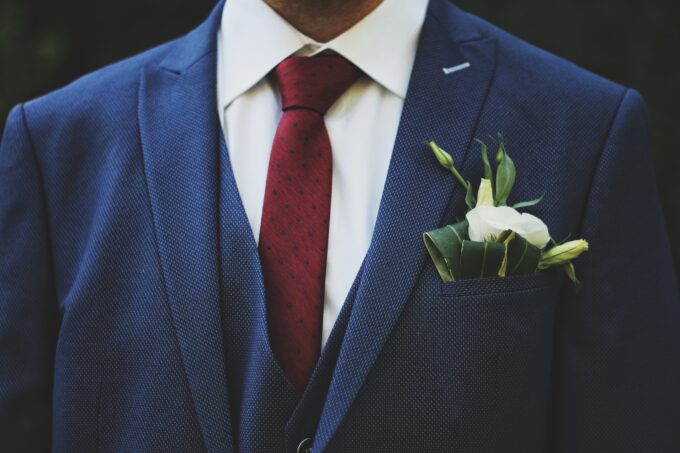 Ein Mann im blauen Anzug mit roter Krawatte.