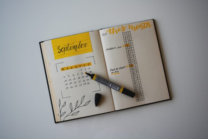 Ein Notizbuch mit Stift und gelbem Kalender.