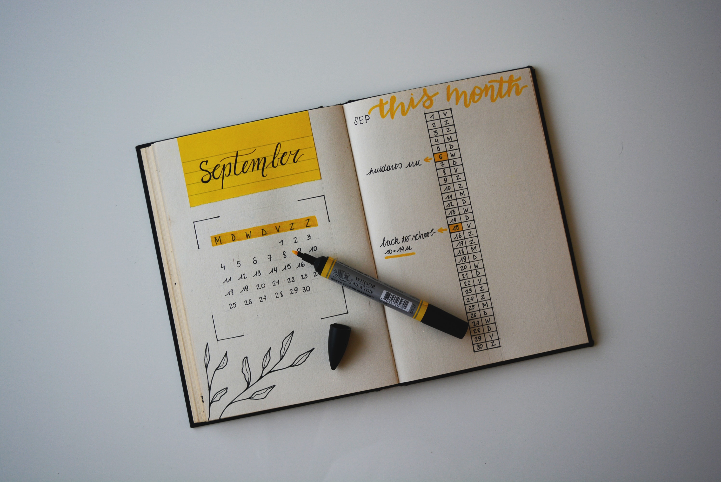 Ein Notizbuch mit Stift und gelbem Kalender.