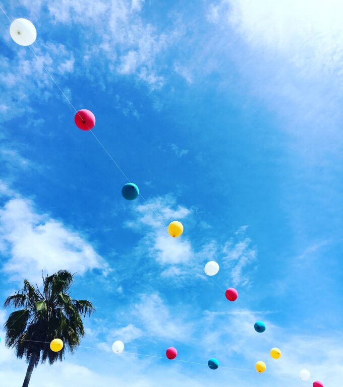 Ein Haufen bunter Luftballons, die in den Himmel fliegen.