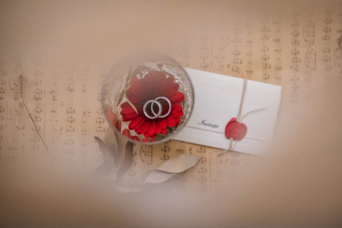 Ein Ehering mit einer roten Blume auf einem Blatt Papier.