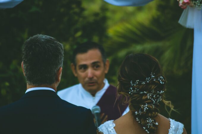Eine Braut und ein Bräutigam schauen sich während einer Hochzeitszeremonie an.