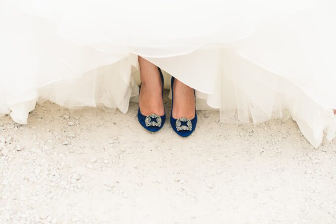 Eine Braut in einem Hochzeitskleid mit blauen Schuhen.
