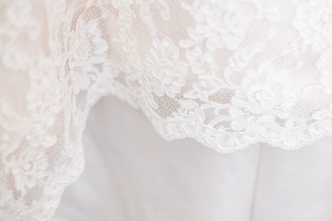 Eine Nahaufnahme eines weißen Hochzeitskleides mit Spitze.