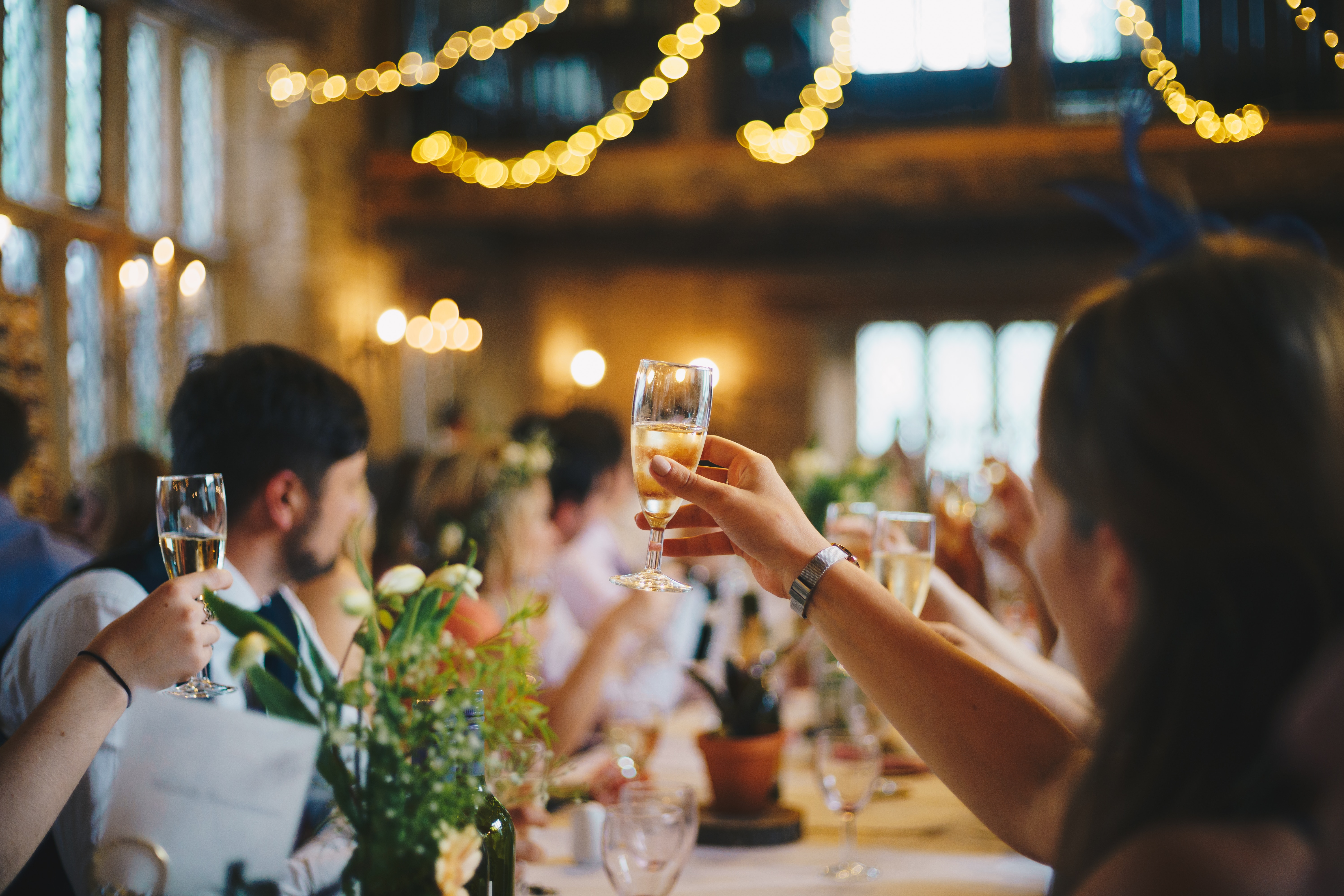 Eine Gruppe von Menschen prostet bei einer Hochzeitsfeier mit Champagner an.