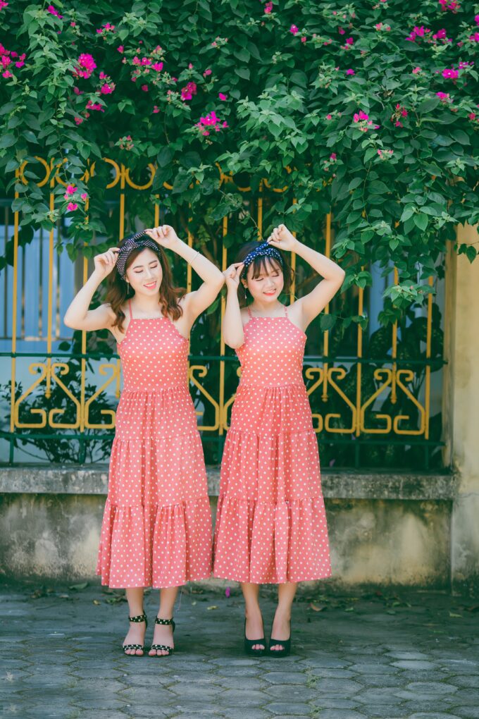 Zwei Frauen in rosa Kleidern posieren für ein Foto.