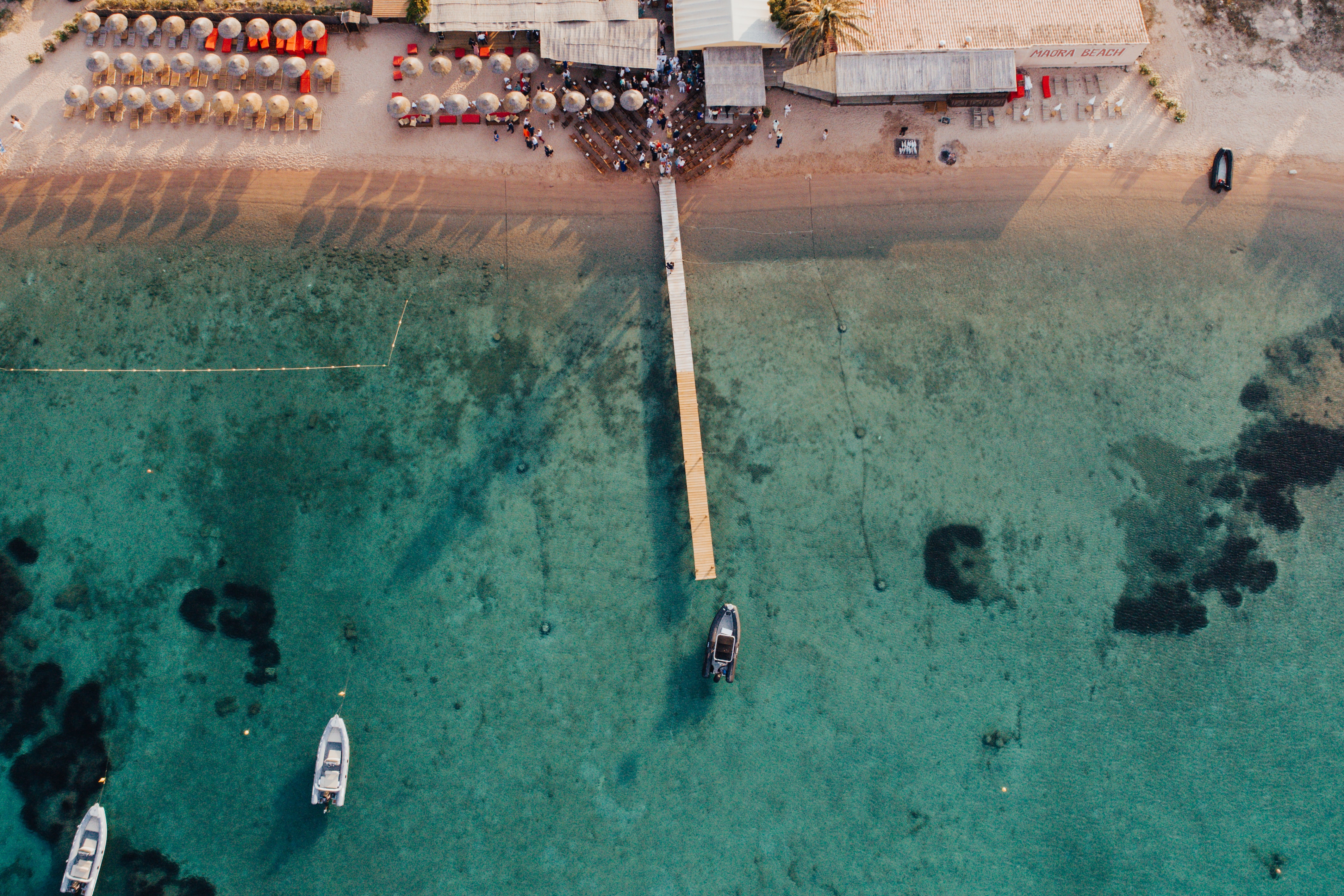 Eine Luftaufnahme eines Strandes mit Booten im Wasser.