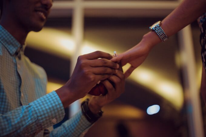 Ein Mann steckt einer Frau einen Ring an die Hand.