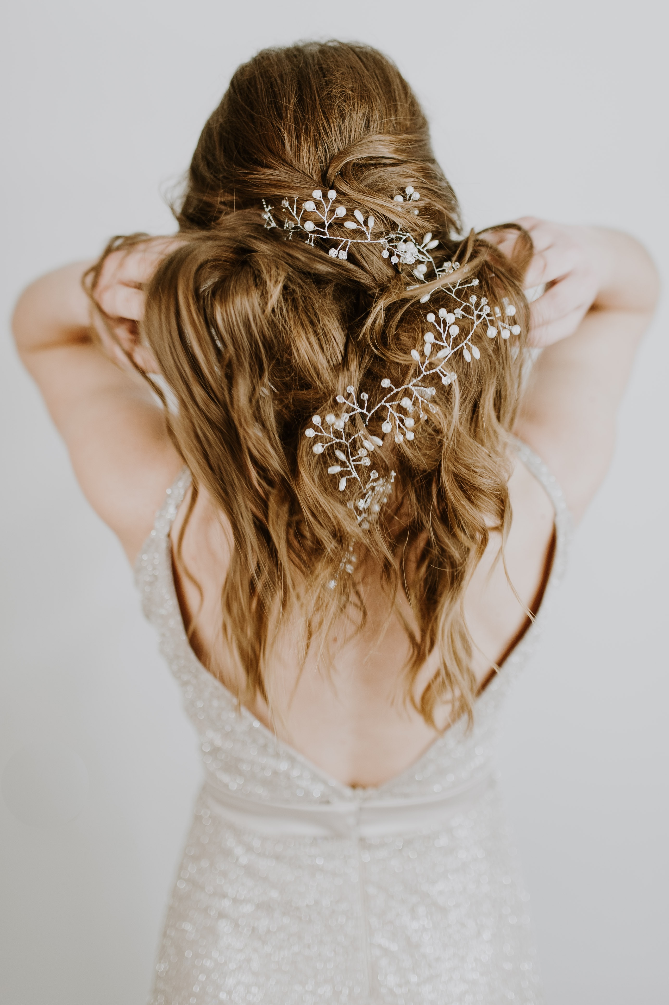 Die Rückseite des Haars einer Frau mit einem Blumenkopfschmuck.