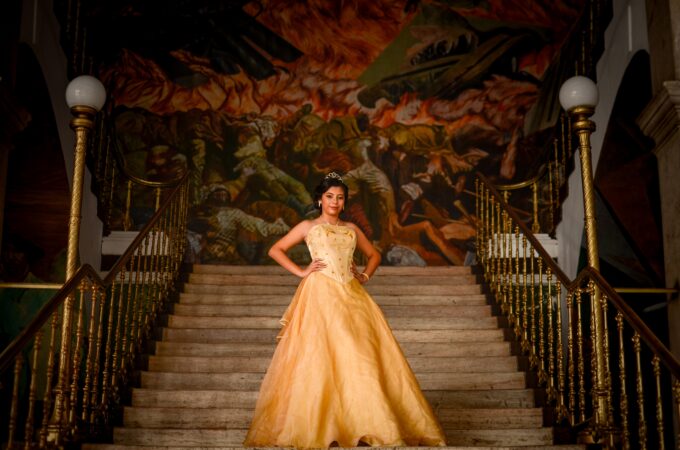 Eine Frau in einem gelben Kleid steht auf einer Treppe.