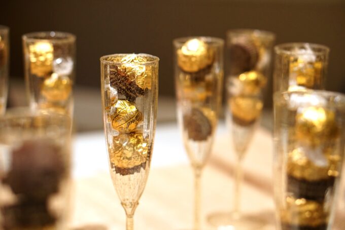 Eine Gruppe Champagnerflöten gefüllt mit Pralinen.