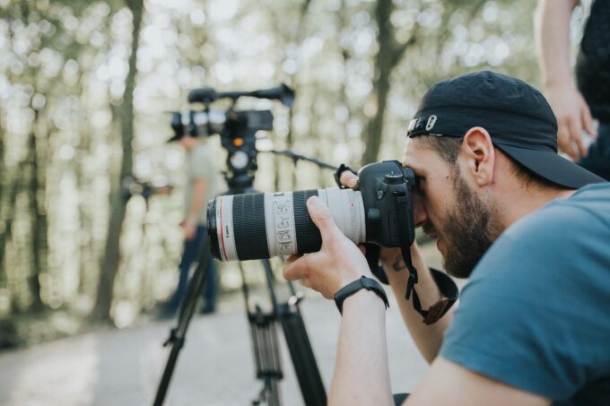 Ein Mann mit einer Kamera fotografiert im Wald.