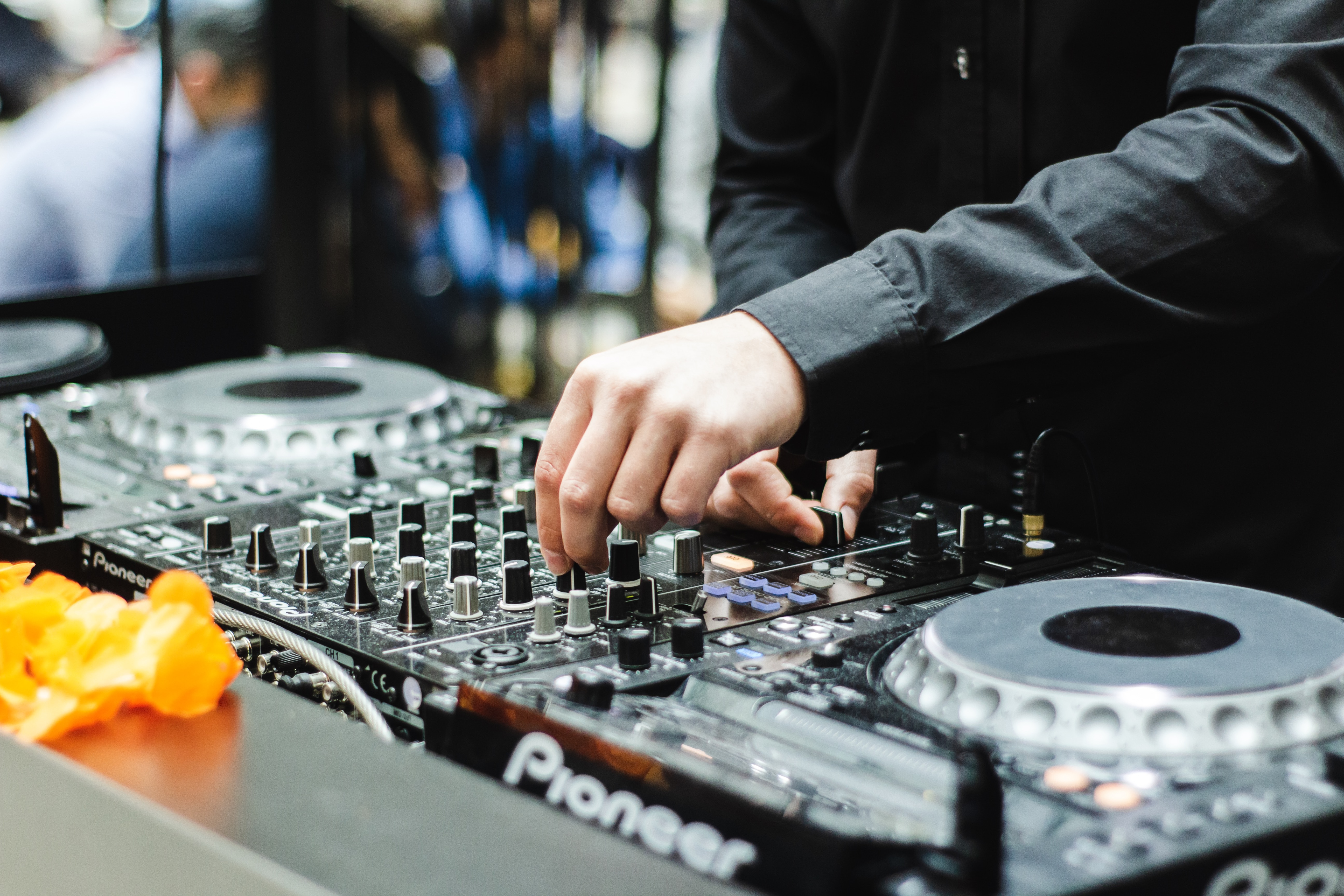 Ein DJ mixt auf einer Party auf einem Plattenspieler.