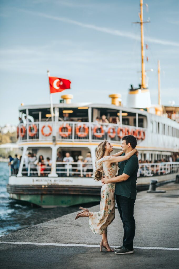 Ein Paar umarmt sich vor einem Boot auf dem Bosporus.