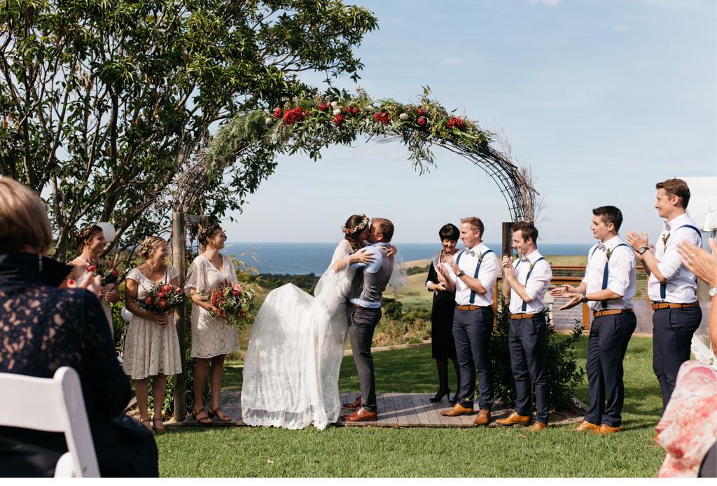 Ein Brautpaar küsst sich bei ihrer Hochzeitszeremonie.