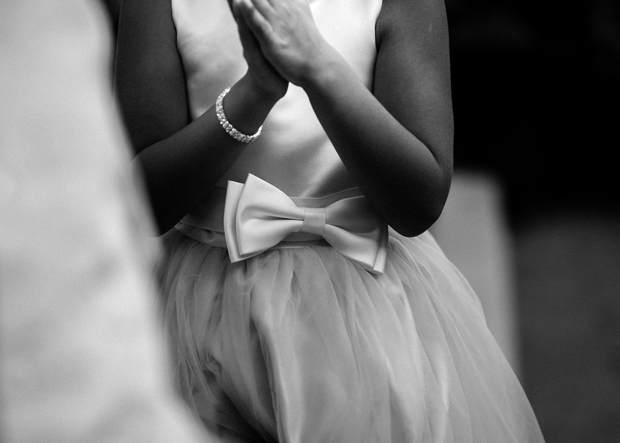 Ein kleines Mädchen in einem weißen Kleid klatscht in die Hände.