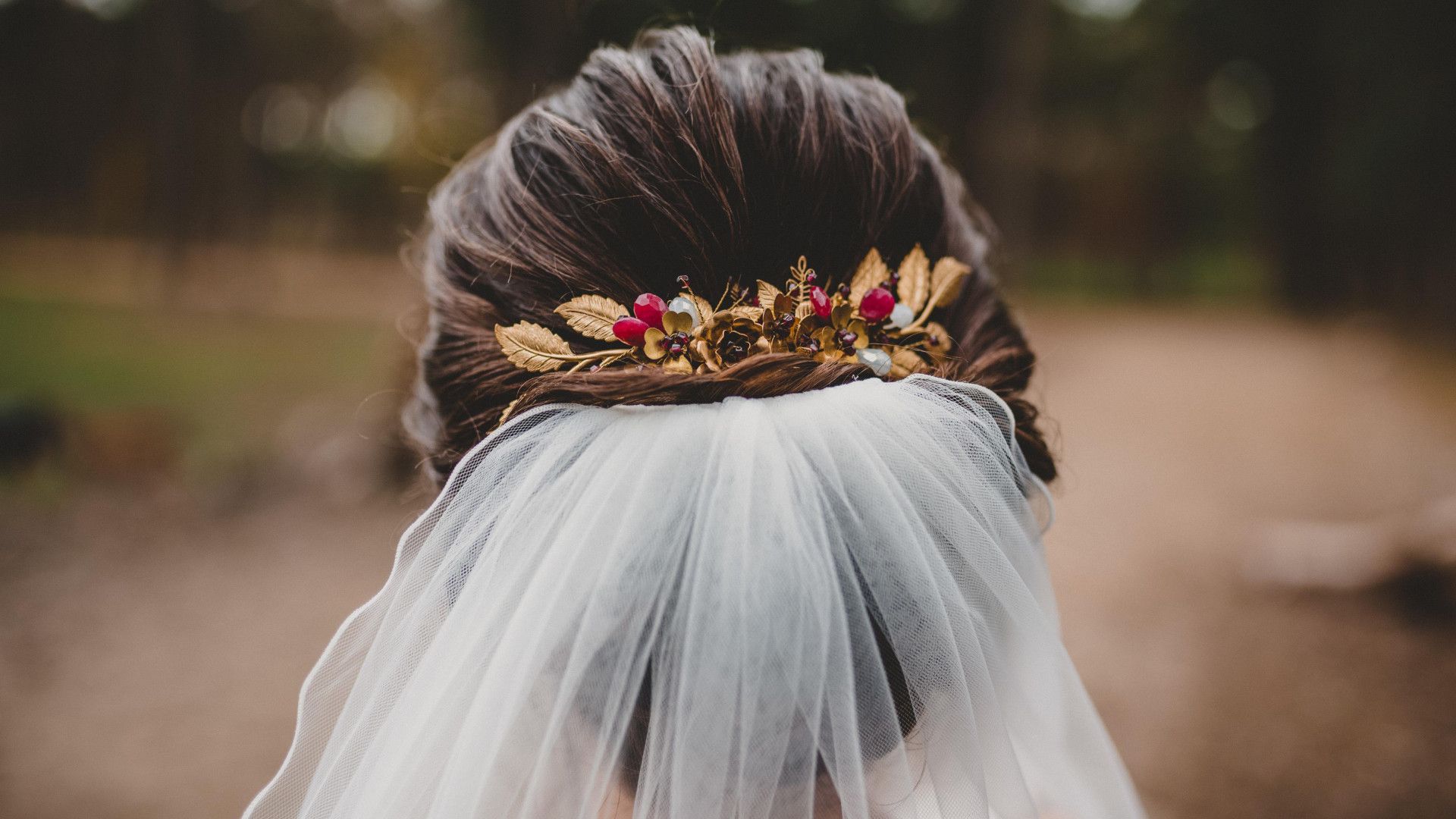 Eine Braut mit Schleier und einer Blume im Haar.