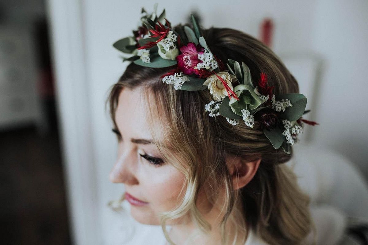Eine Braut mit einer Blumenkrone auf dem Kopf.