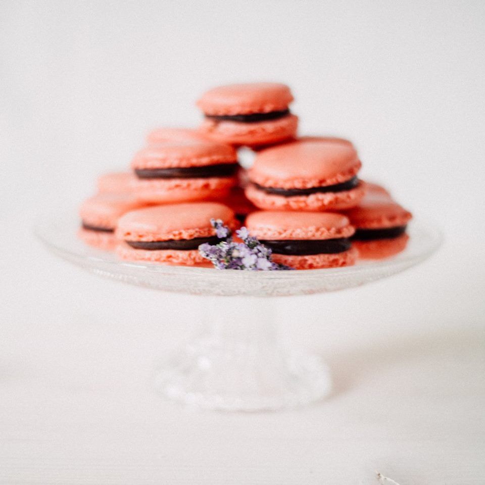 Rosa Macarons auf einer Glasplatte.