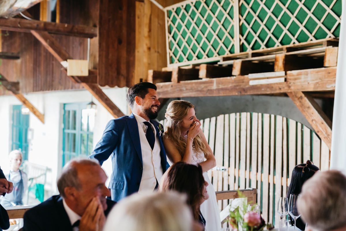 Eine Braut und ein Bräutigam bei einem Hochzeitsempfang in einer Scheune.