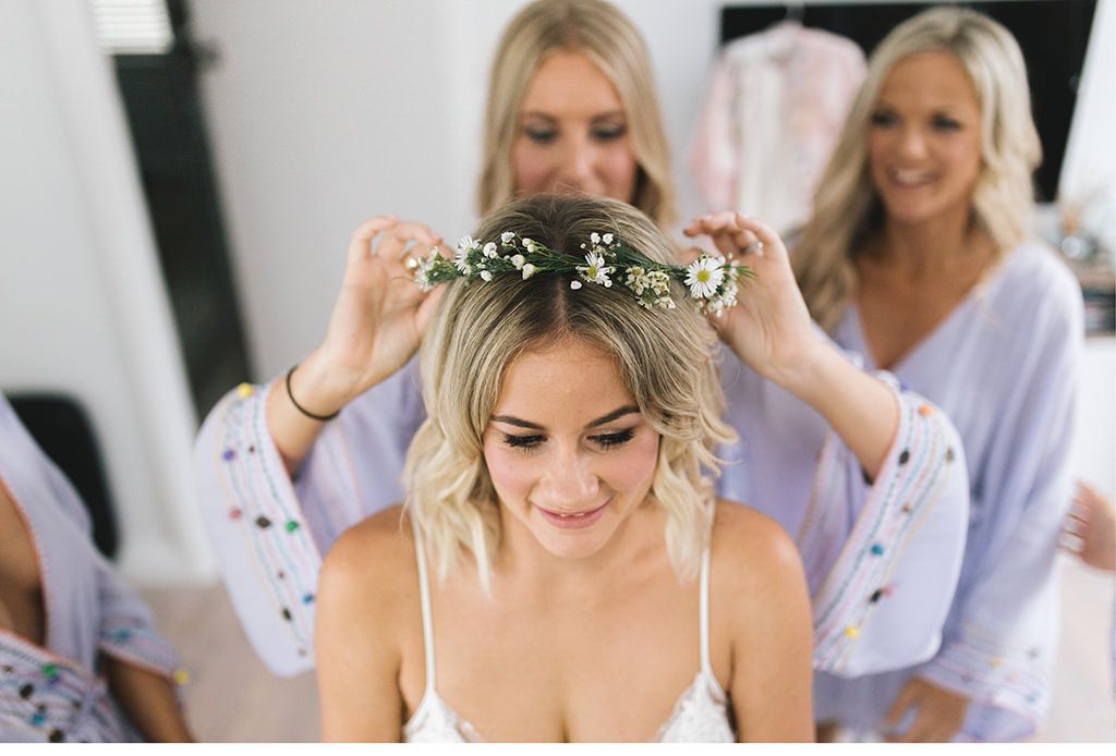 Eine Braut lässt sich von ihren Brautjungfern die Haare frisieren.