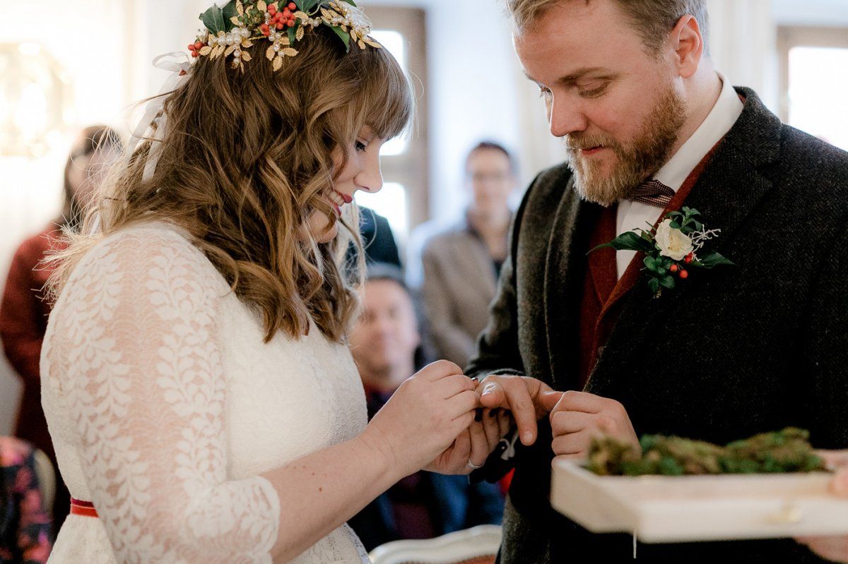 Eine Braut und ein Bräutigam legen sich gegenseitig Ringe an.