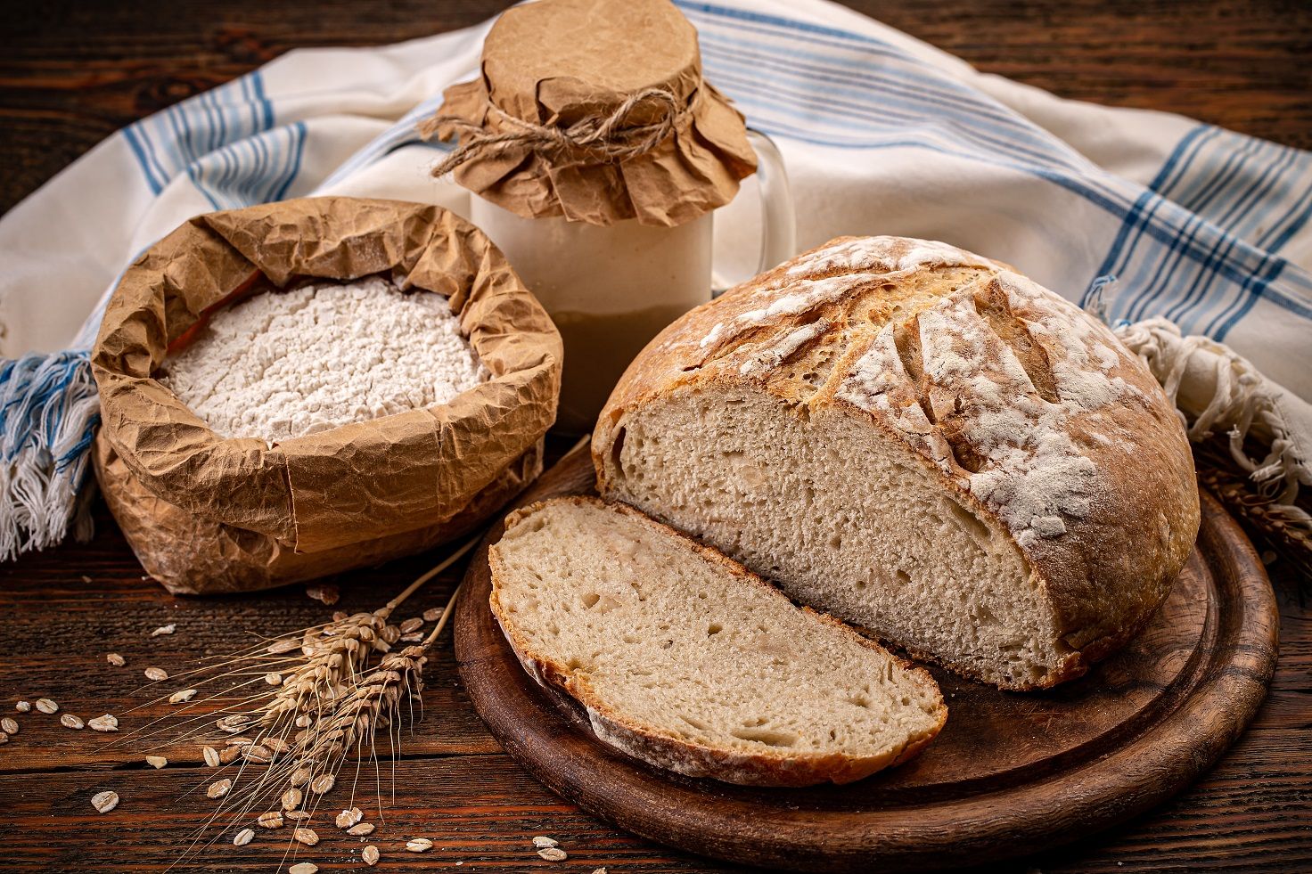 Ein Laib Brot und eine Flasche Milch auf einem Holztisch.