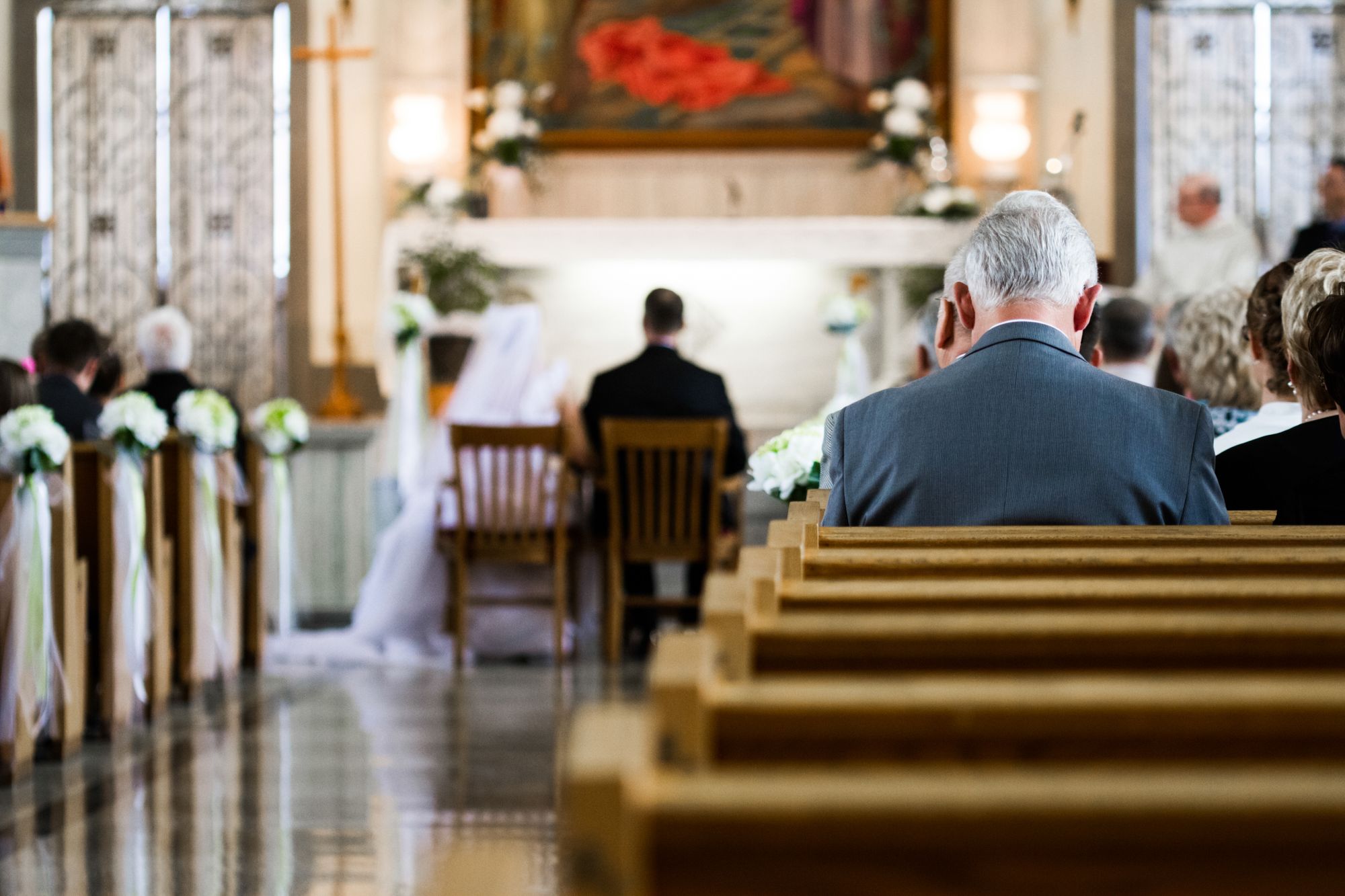 Eine Hochzeitszeremonie in einer Kirche mit Menschen, die in Kirchenbänken sitzen.