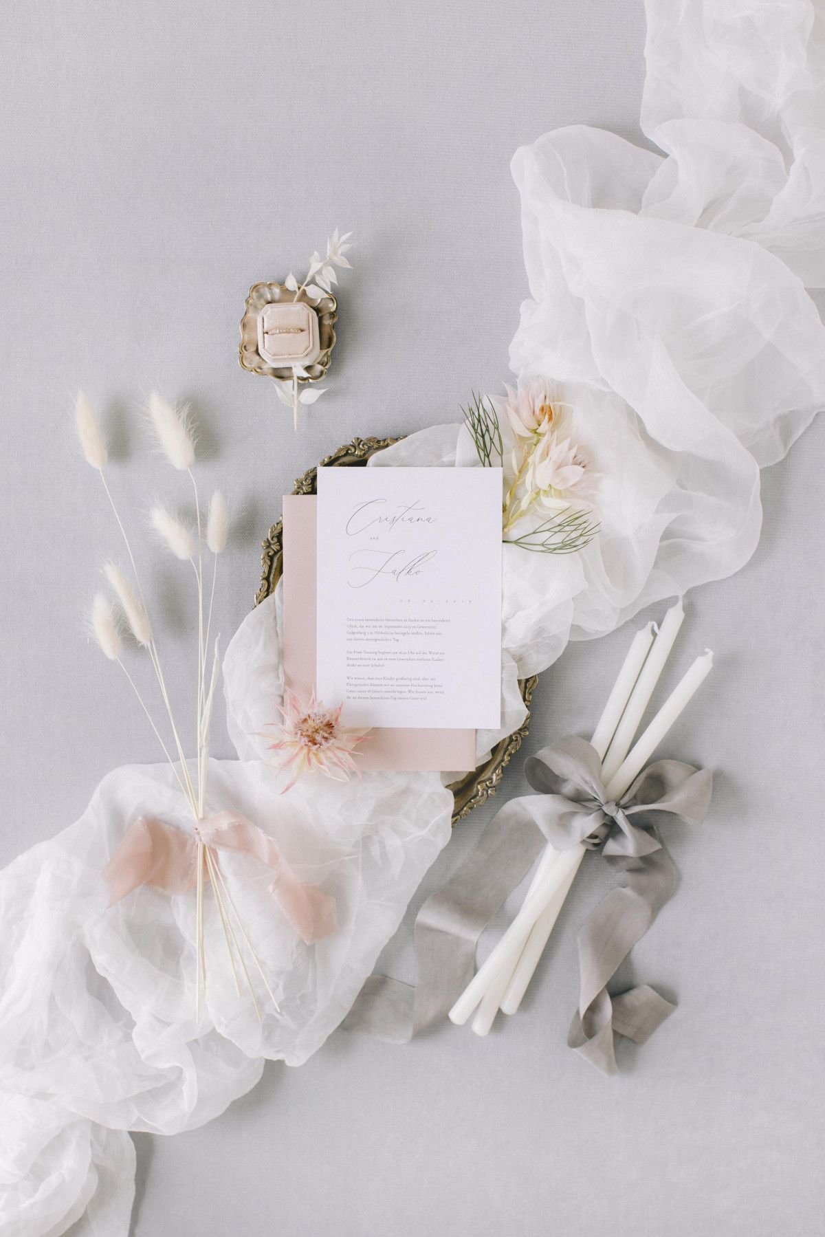Ein Hochzeitsbriefpapier auf einem Tisch mit Blumen und Bändern.